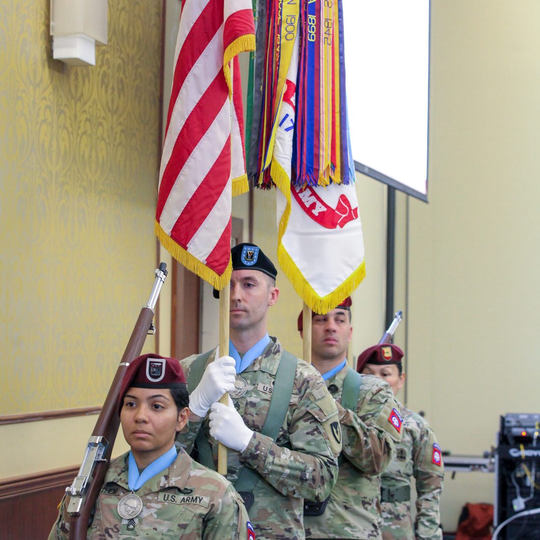 A color guard detail presenting the United States flag and unit colors at a chapter event